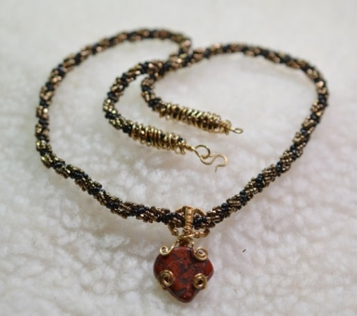 Black and Bronze Spiral Bead Necklace with Brass Wire Wrapped Red and Black Stone Pendant
