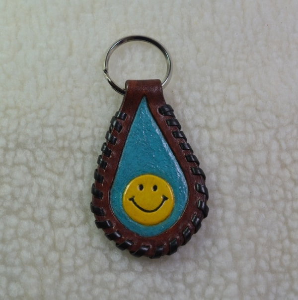 Brown and turquoise leather keyfob with Have a Nice Day happy face